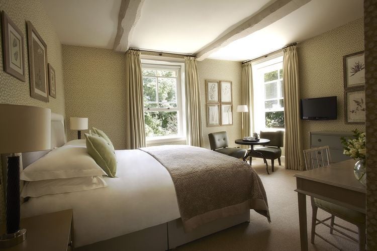 Luxurious hotel room with plush white bedding, contemporary design, soft neutral tones, and elegant spa-like bathroom at Dormy House Hotel in the United Kingdom