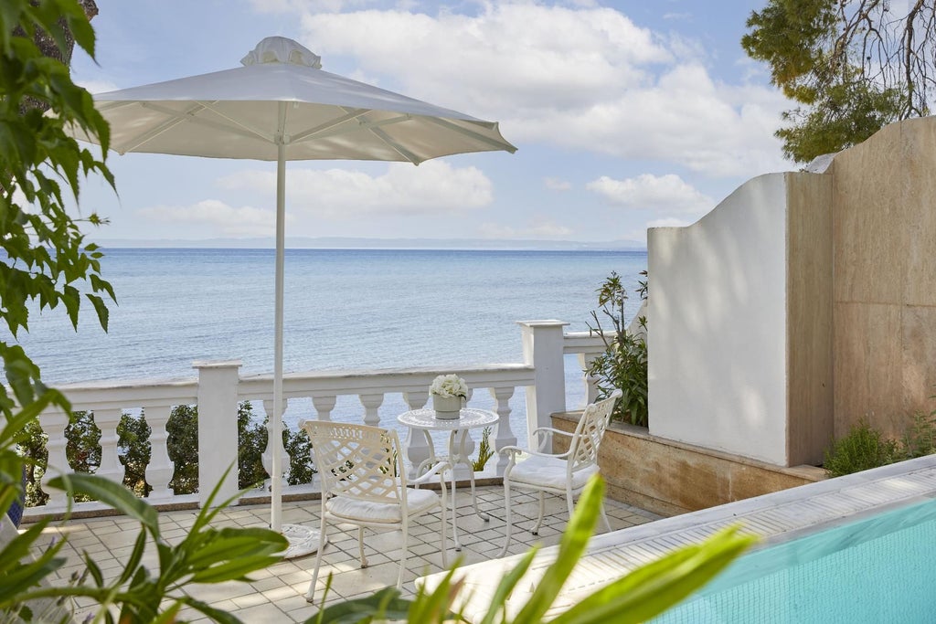 Luxurious executive pool suite with elegant wooden decor, private infinity pool overlooking azure Aegean Sea, and minimalist Mediterranean design at scenic resort.