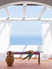 Luxurious white-washed boutique hotel with traditional Mediterranean architecture, overlooking azure Aeolian Islands coastline and pristine blue waters