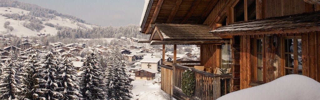 Luxurious alpine chalet with snow-covered peaks, elegant wooden facade, warm glowing windows nestled in a serene French mountain landscape at dusk