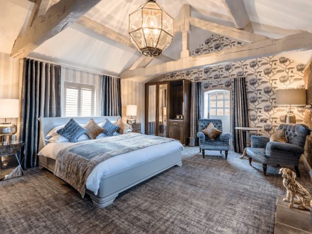 Elegant superior room at The Scenset Inn, featuring plush bedding, warm wooden furniture, and soft neutral tones with rustic countryside charm