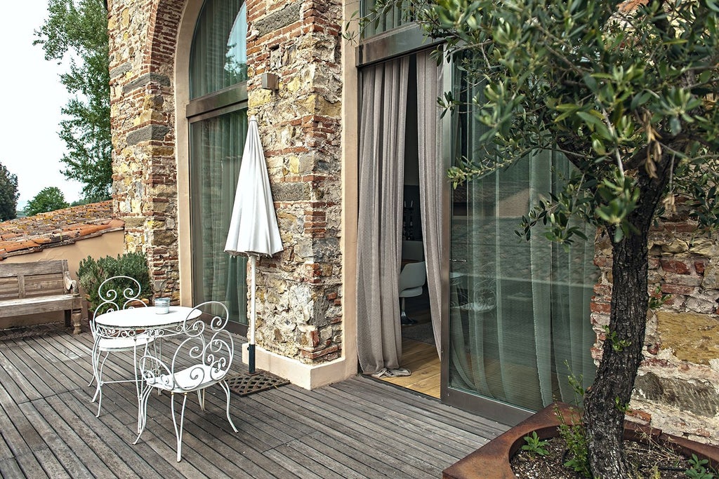 Minimalist modern loft suite with exposed wooden beams, sleek design, and large windows overlooking Tuscan landscape in a luxurious Italian hotel