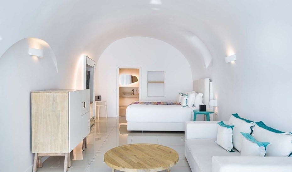 Elegant white-washed Santorini suite with private infinity pool overlooking azure Aegean Sea, featuring minimalist design and breathtaking panoramic coastal views