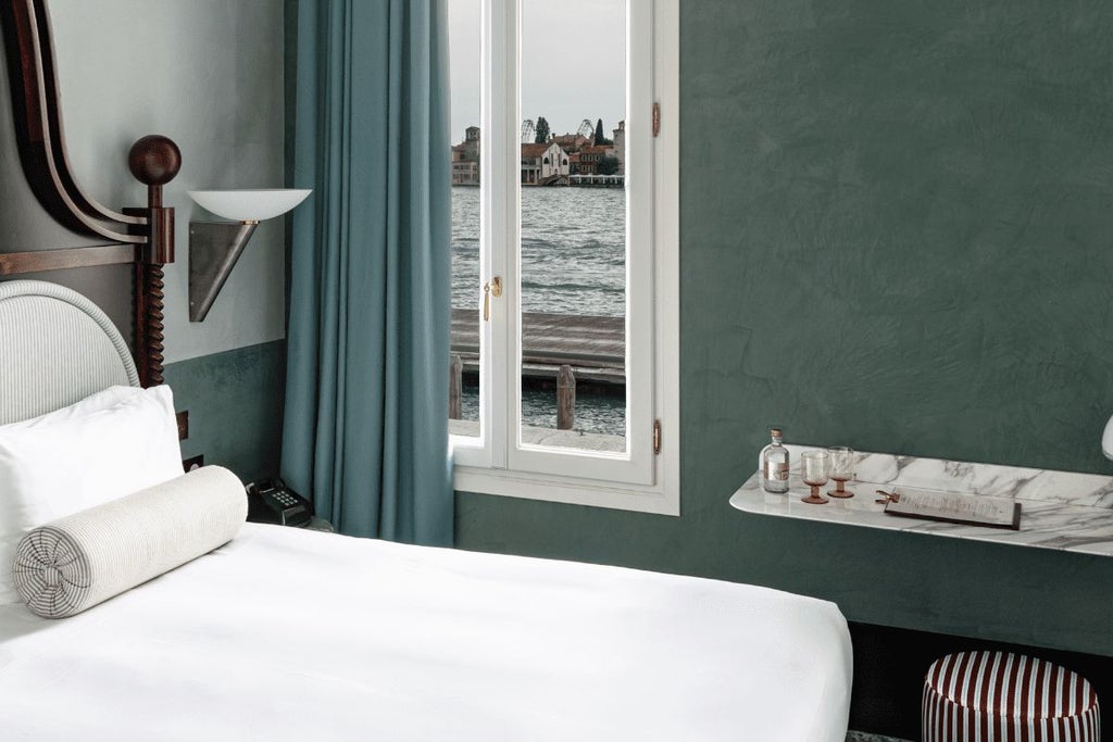 Elegant Venetian hotel room with canal view, featuring plush white bedding, ornate light fixtures, and expansive windows overlooking scenic waterway