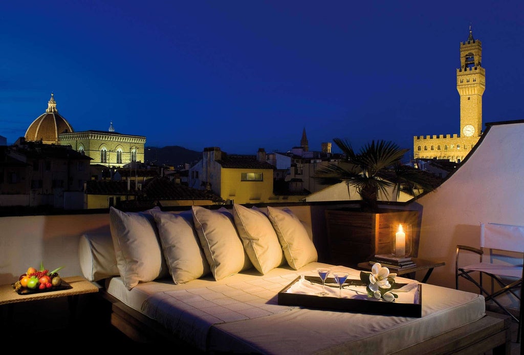 Elegant boutique hotel in Florence with modern stone facade, stylish entrance featuring glass doors and warm accent lighting