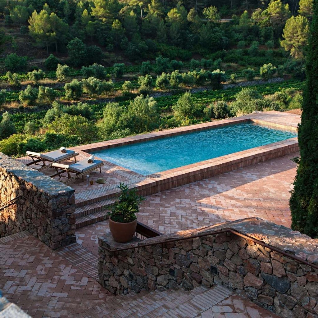 Luxurious stone winery hotel with rustic terracotta roofs nestled among vineyards, showcasing Spanish countryside elegance and architectural heritage.