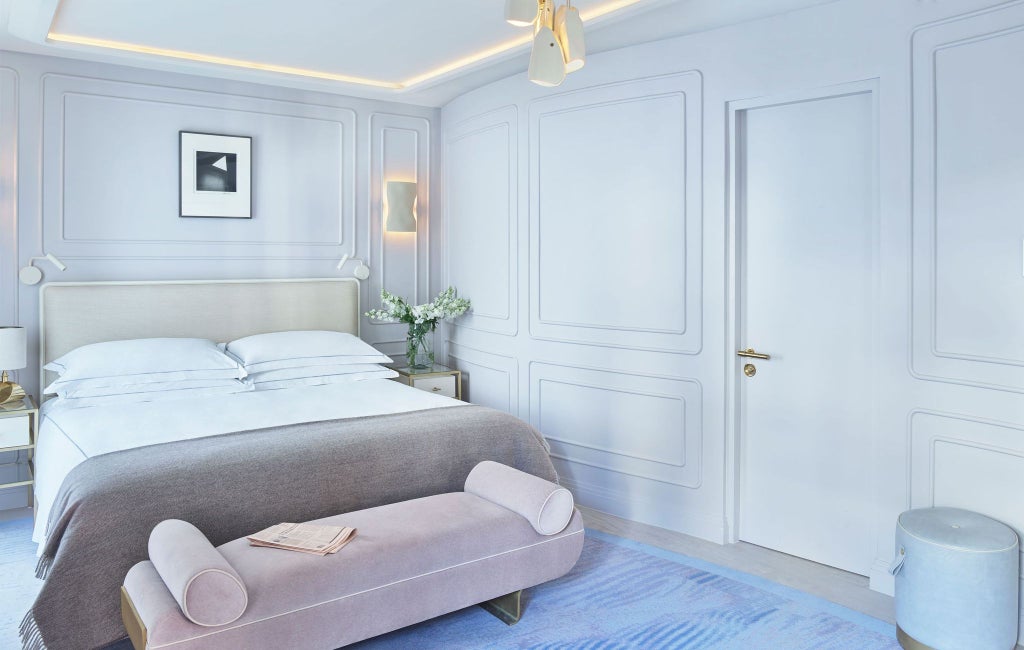 Luxurious corner suite at One Aldwych hotel, featuring elegant contemporary decor, plush king bed, city views, and sophisticated neutral color palette