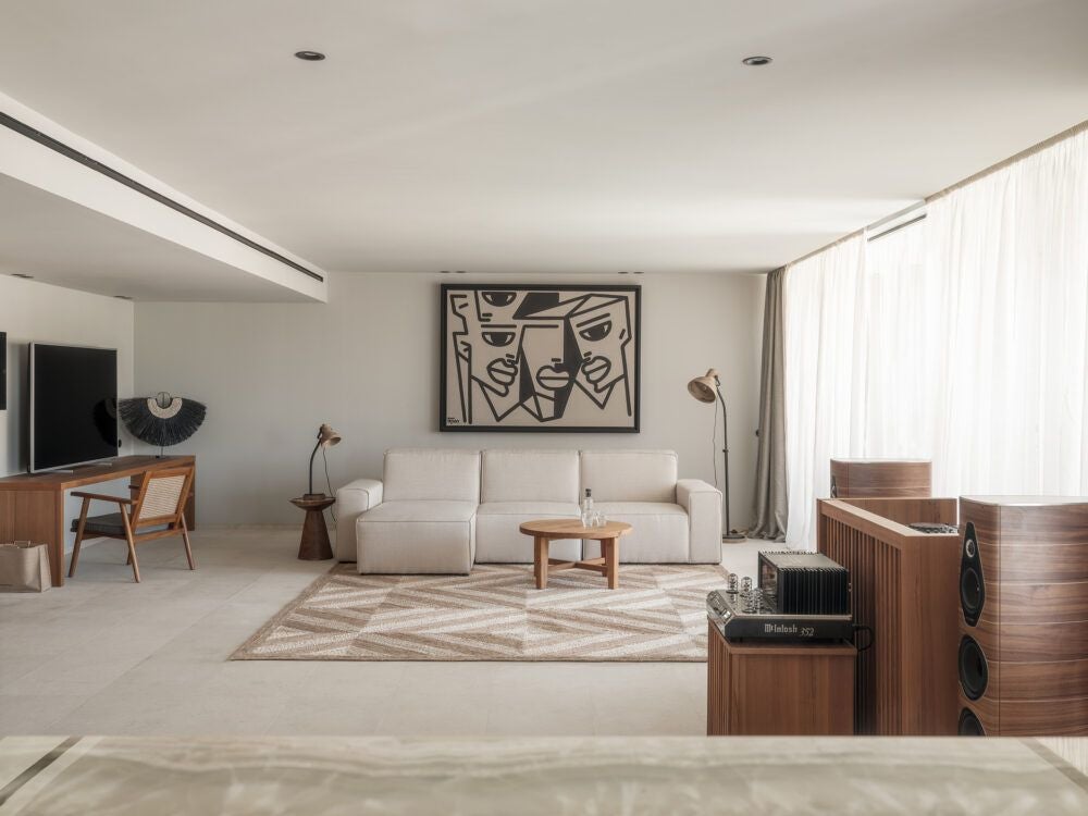 Elegant OKU Signature Suite with minimalist white decor, plush bed, and panoramic balcony overlooking serene Ibiza landscape at twilight