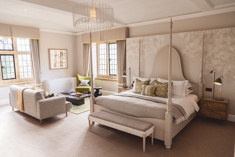 Elegant chestnut-toned bedroom at Foxhill Manor with plush white bedding, antique wooden furniture, and soft natural lighting through large windows