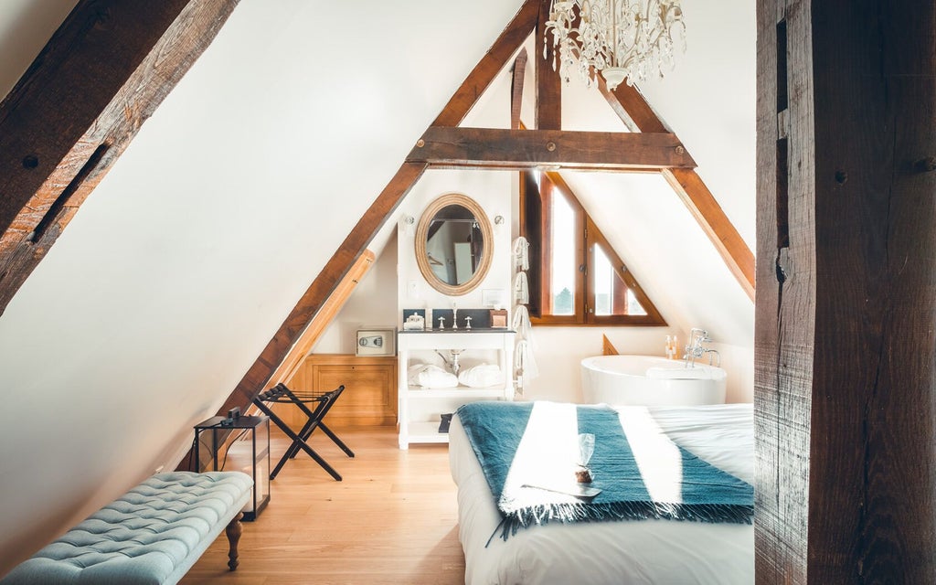 Elegant French manor bedroom with soft neutral tones, plush bedding, antique wooden furniture, and warm ambient lighting creating a cozy sanctuary