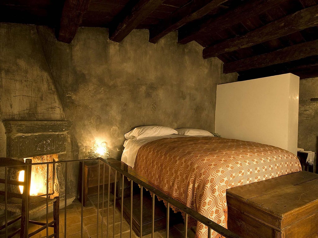 Rustic Italian stone hotel room with arched window overlooking historic village, antique wooden furniture, and soft warm lighting creating an intimate atmosphere