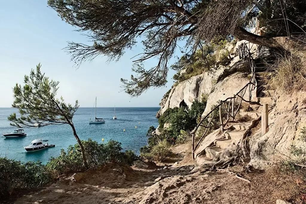 Luxurious stone tower hotel with Mediterranean coastal views, rustic terracotta roof, ancient architecture nestled in scenic Spanish landscape