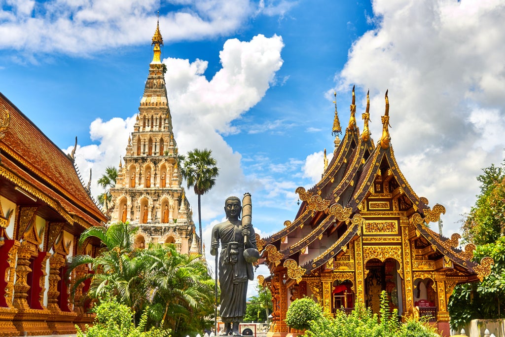 Opulent Bangkok street with gleaming golden temples, vibrant tuk-tuks, and traditional silk-clad locals amid bustling urban landscape of Thailand's capital