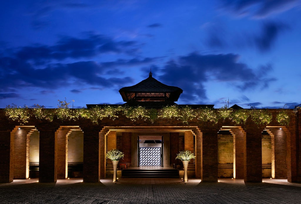 Grand five-star resort with traditional Balinese architecture nestled in lush tropical valley, featuring infinity pools and private villas