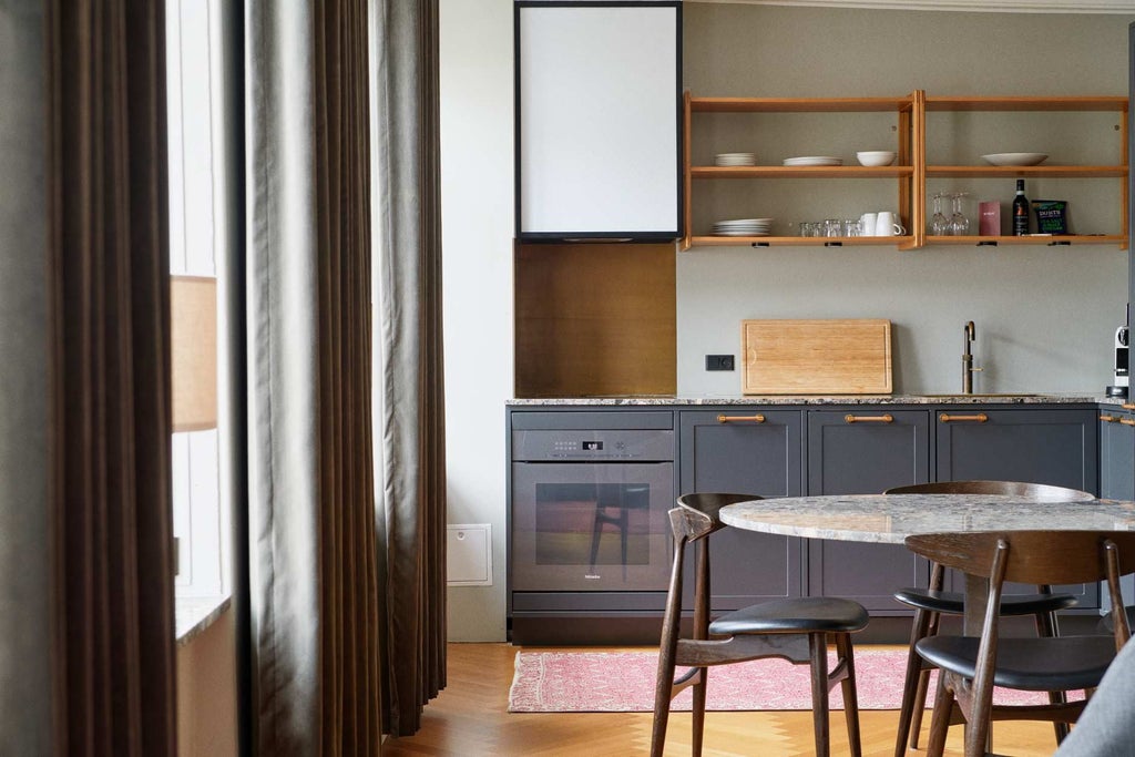 Elegant modern hotel room with minimalist Danish design, light wooden floors, white walls, and stylish contemporary furnishings in neutral tones