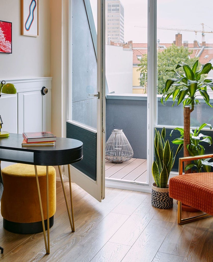 Stylish urban hotel room with modern design, sleek furniture, large windows, muted color palette, and panoramic view of Berlin's Ku'damm district