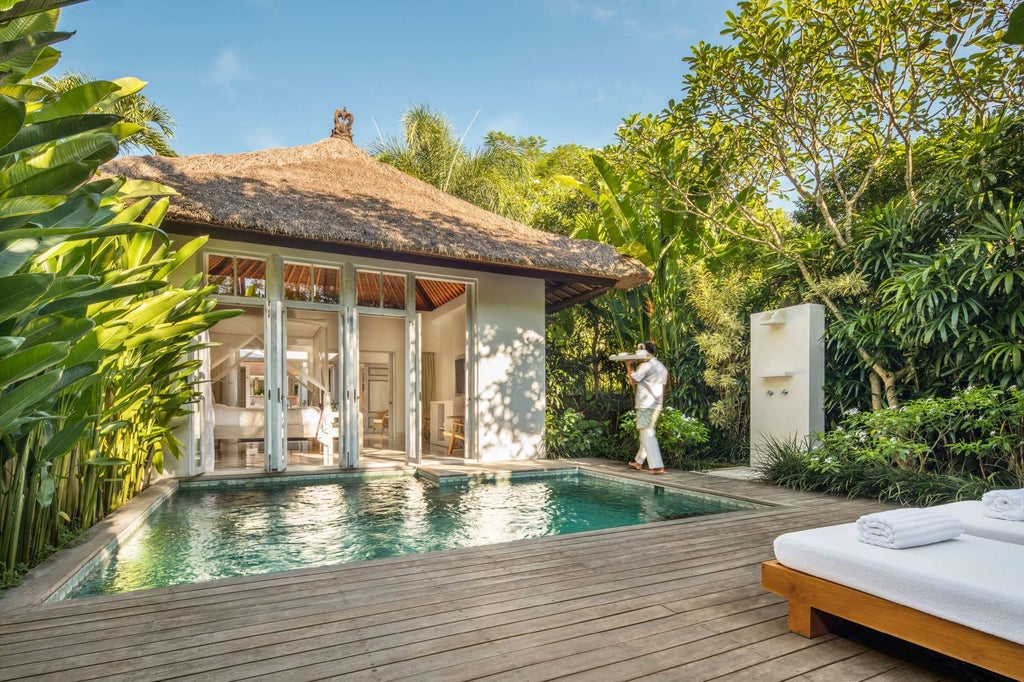 Luxurious Balinese resort nestled among lush tropical greenery, featuring elegant traditional architecture with open-air pavilions and infinity pool overlooking verdant landscape