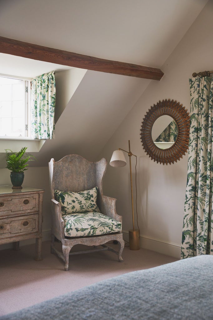 Elegant thyme-green bedroom with plush white linens, minimalist wooden furniture, and soft ambient lighting in a luxurious UK hotel suite