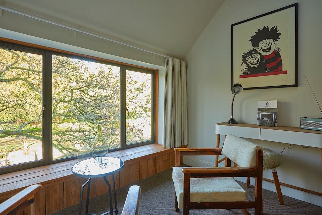 Elegant mezzanine double hotel room with contemporary design, crisp white linens, warm wood accents, and soft ambient lighting in a charming UK boutique setting