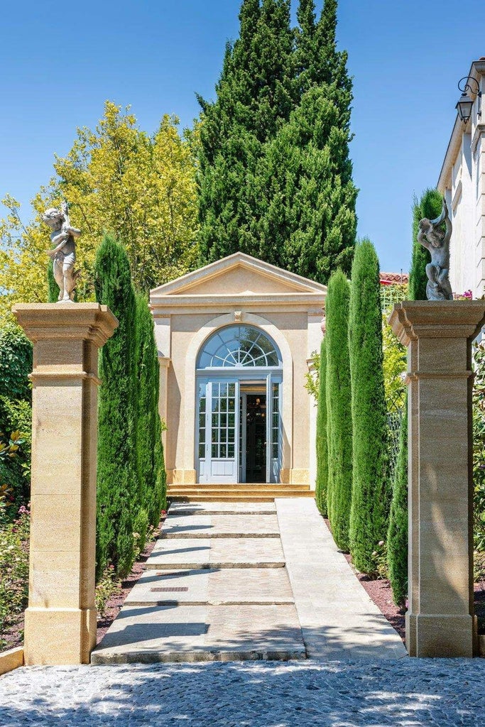 Elegant lavender-framed French Provençal hotel with lush gardens, terracotta roof, and pristine white facade nestled in scenic Aix-en-Provence landscape