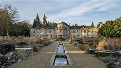 Elegant Grantley Hall, a restored Georgian manor with manicured gardens, showcasing luxurious architecture and pristine landscaping in the scenic United Kingdom countryside.