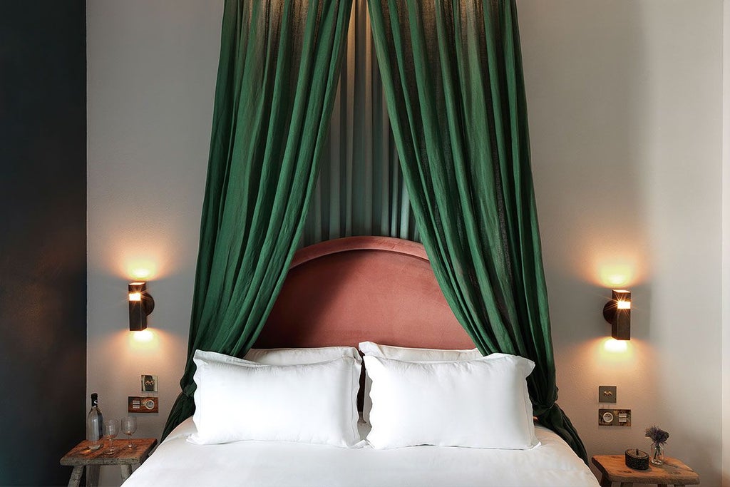 Elegant Parisian hotel room balcony with ornate wrought-iron railing overlooking a charming street at Hôtel des Grands Boulevards, bathed in soft golden light