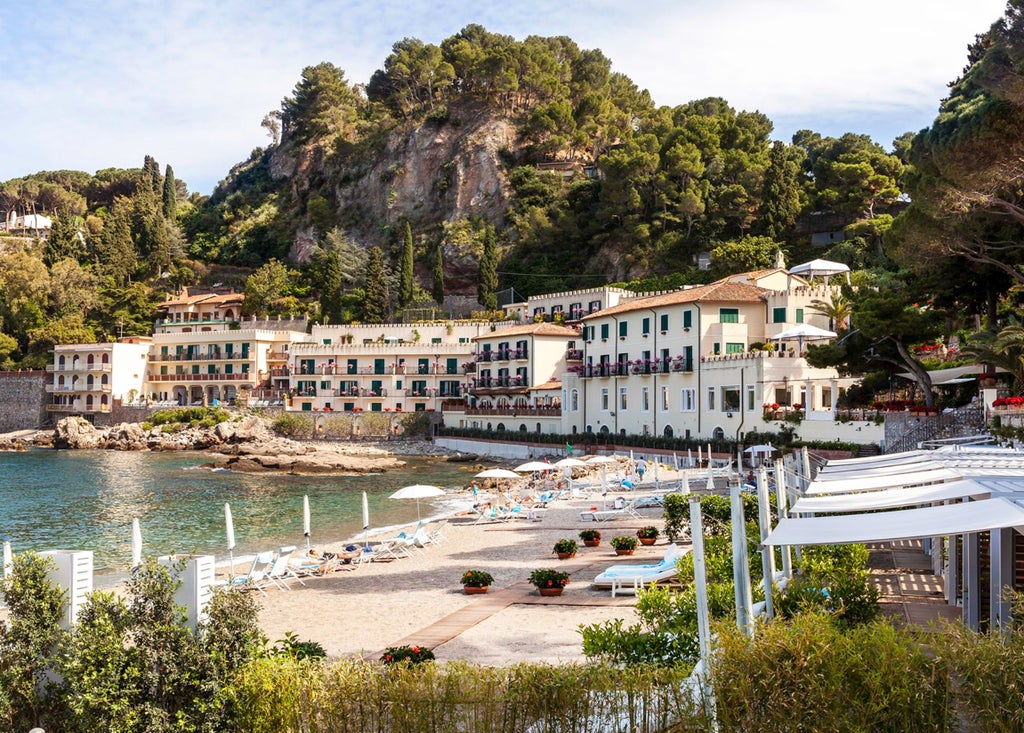 Panoramic sunset view of Taormina, Sicily, with ancient Greek theater ruins overlooking the Mediterranean Sea and Mount Etna volcano