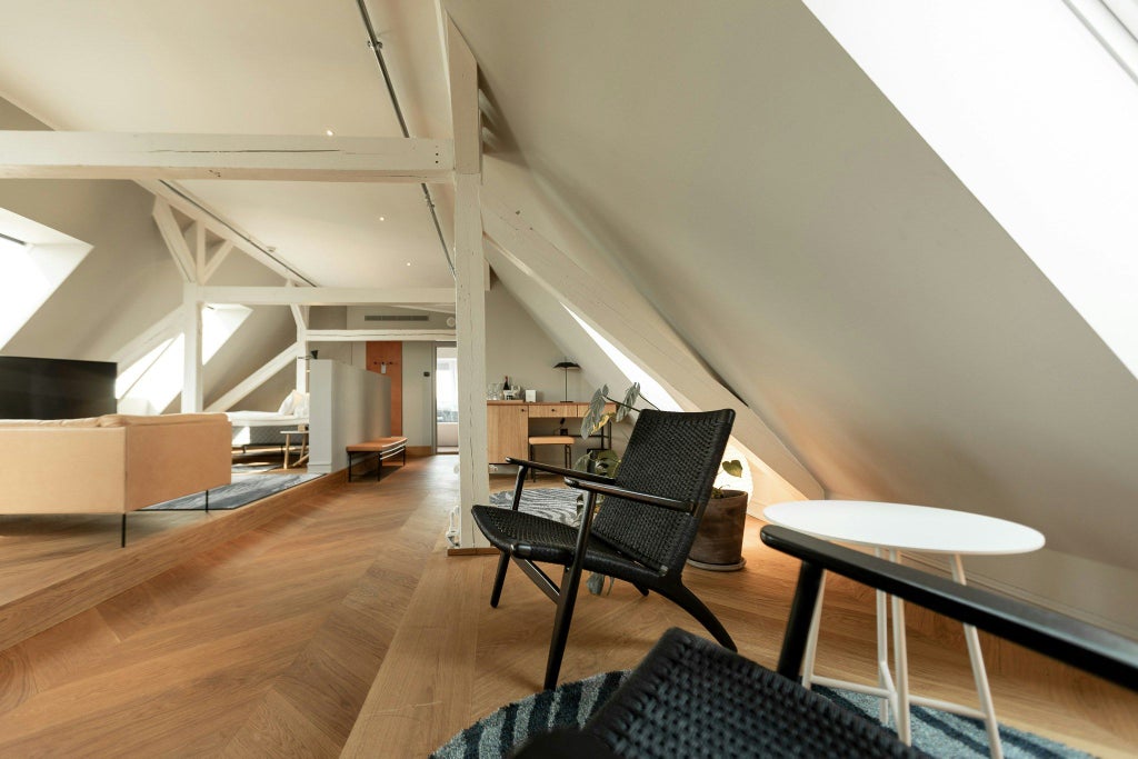 Luxurious penthouse suite with modern Danish design, expansive city views, elegant king bed, and sleek minimalist furnishings in Scenset Hotel Copenhagen