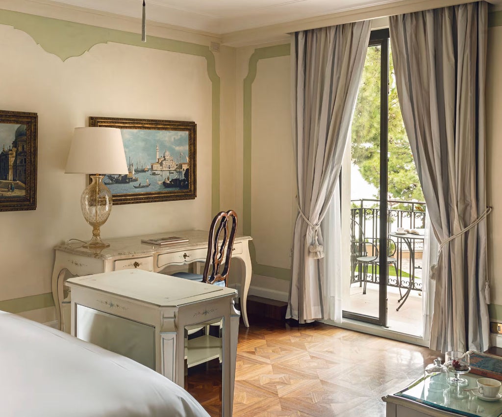 Elegant double hotel room with Venetian-style decor, king bed, antique furniture, crystal chandelier and garden views through arched windows