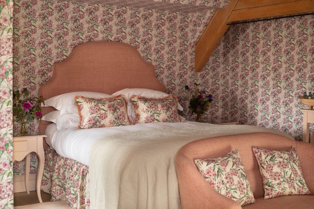 Luxurious hotel bedroom with soft neutral tones, crisp white linens, plush headboard, and elegant minimalist design characteristic of UK boutique accommodations