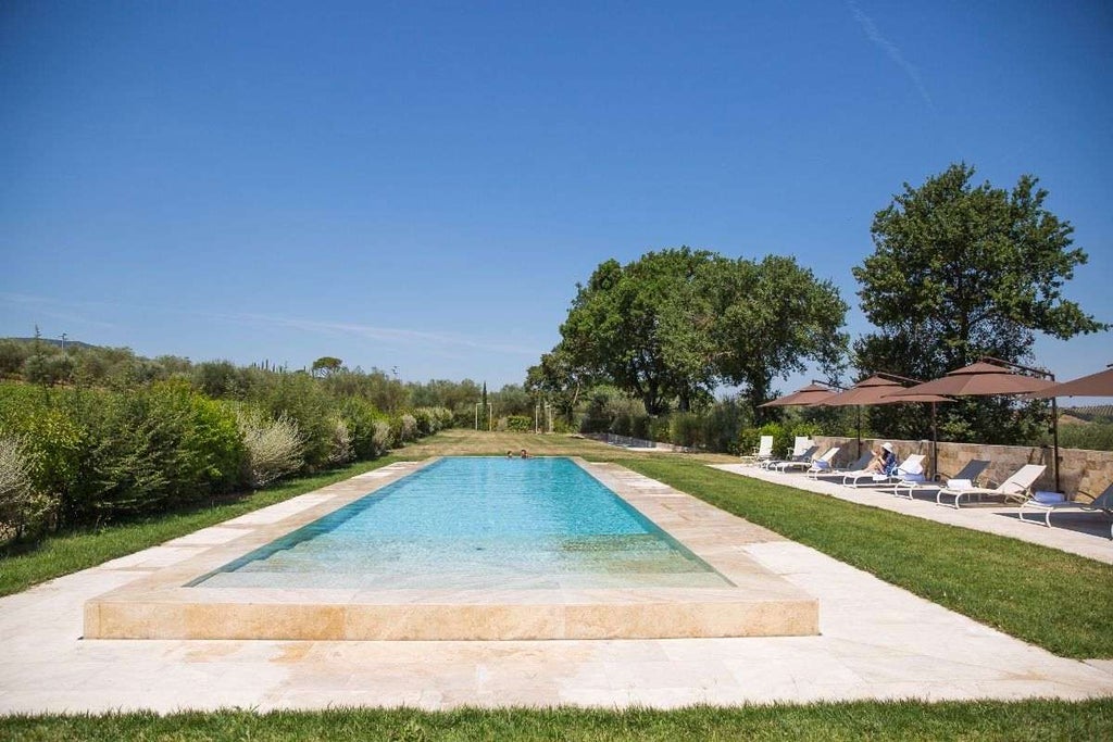 Mediterranean luxury villa with stone facade, arched windows, and manicured garden featuring a grand entrance and elegant outdoor seating area