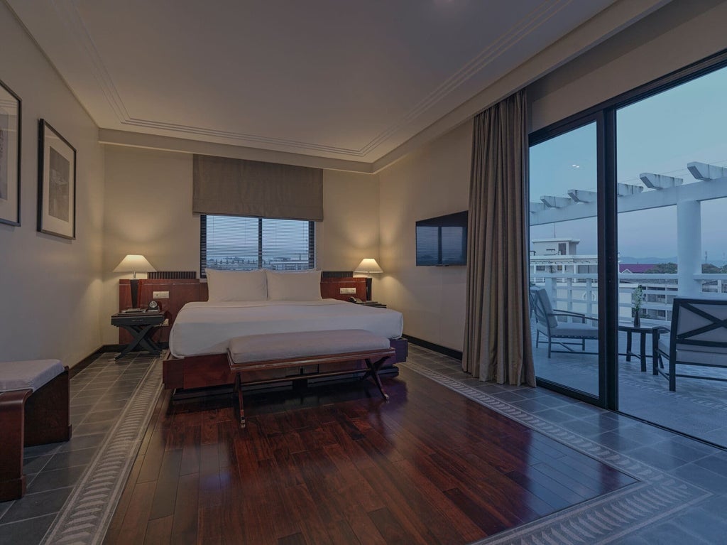 Elegant Perfume River Suite with French colonial-inspired decor, river view, plush white linens, and traditional Vietnamese architectural details at Azerai La Residence