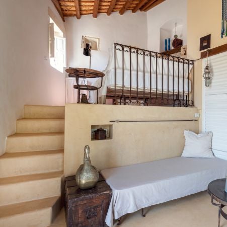 Rustic-chic Italian hotel room with stone walls, minimalist design, warm terracotta tones, and elegant wooden furnishings overlooking scenic countryside