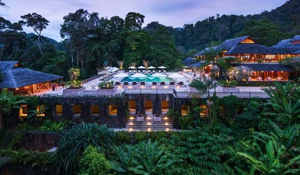 Luxurious wooden villa nestled in Malaysian rainforest canopy at The Datai Langkawi, featuring private balcony and tropical views