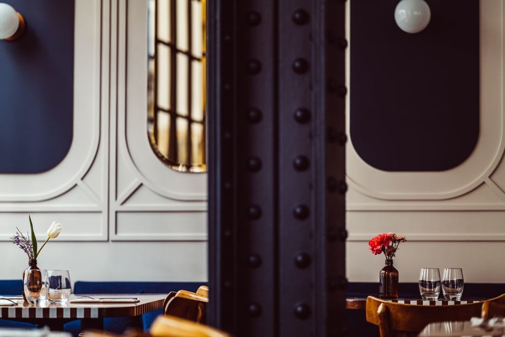 Elegant boutique hotel facade in Paris with Art Deco styling, warm golden lighting, wrought-iron balconies, and classic Parisian architectural charm