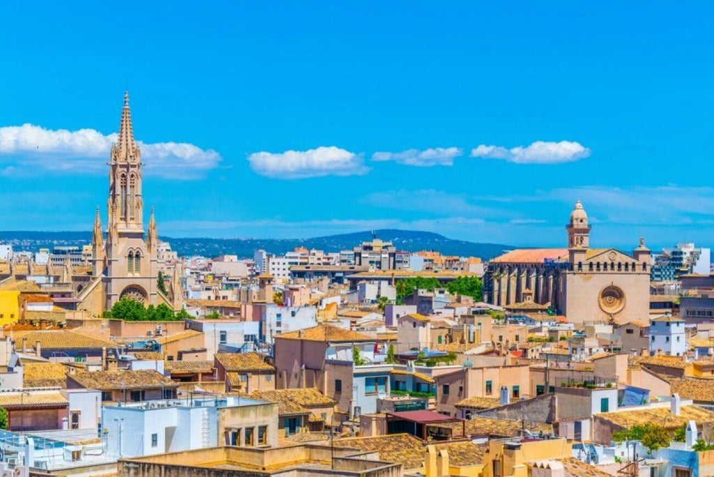 Elegant boutique hotel with stone facade, arched windows, and classic Mediterranean architectural details in a historic Spanish setting