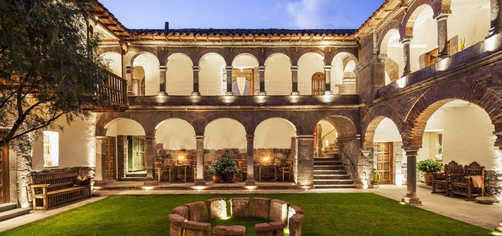 Colonial-style luxury boutique hotel with stone archways, ornate wood balconies and traditional Peruvian architecture in Cusco's Plaza