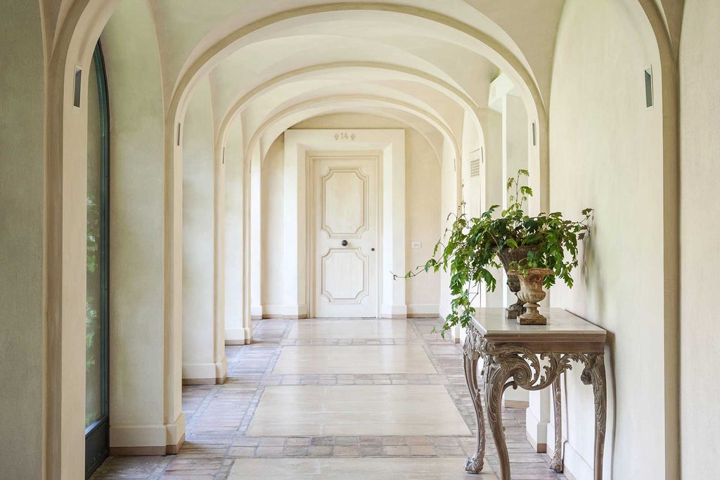 Luxurious Tuscan countryside resort with stone villa, manicured cypress-lined driveway, and elegant golden-hour lighting across expansive rural landscape