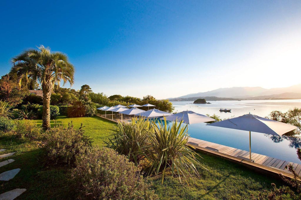 Elegant beachfront hotel with Mediterranean-style white facades, private balconies and manicured gardens overlooking turquoise waters