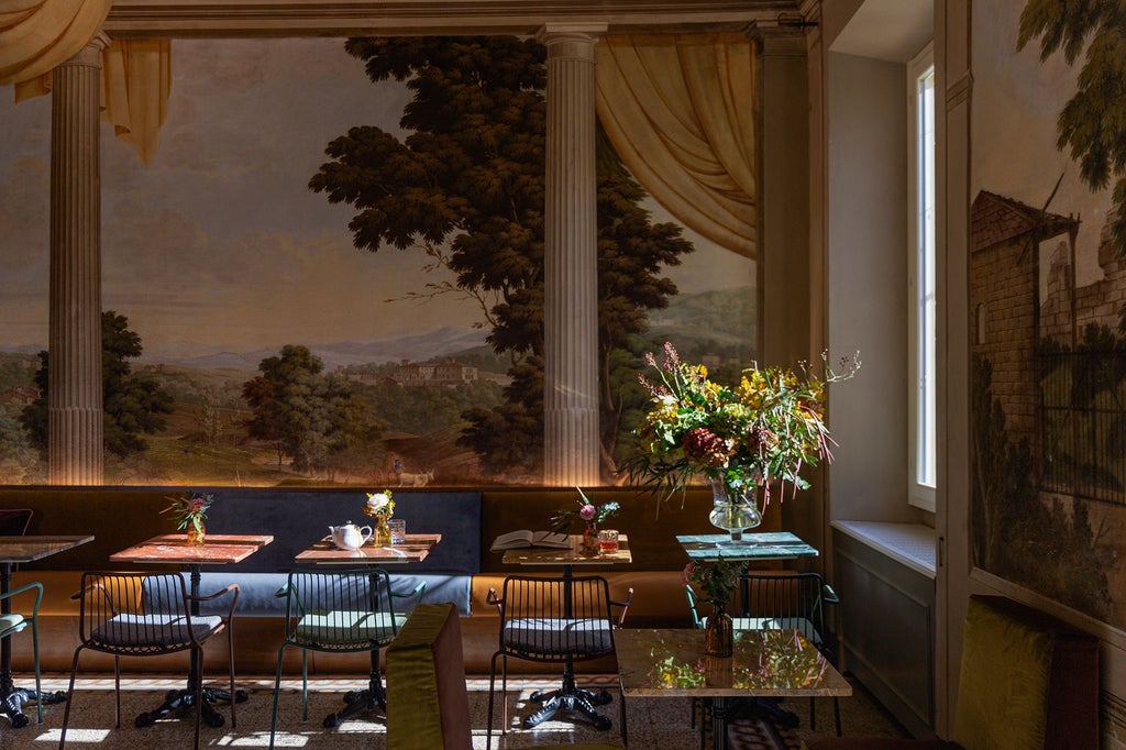 Luxurious boutique hotel room in Florence, Italy, with antique furniture, ornate ceiling, and elegant design showcasing Renaissance-inspired decor