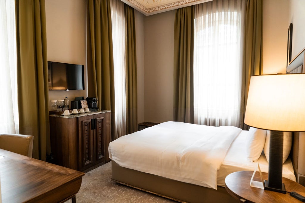 Elegant superior king room with plush bedding, modern Turkish-inspired decor, rich wooden furnishings, and soft ambient lighting at a luxurious hotel in Istanbul.