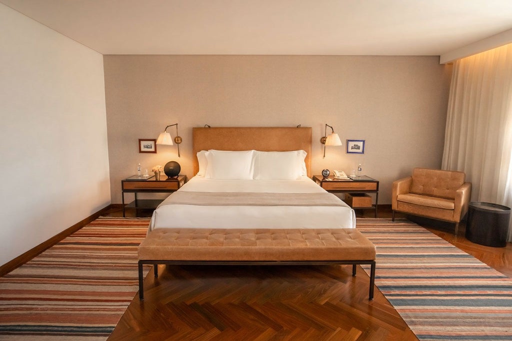 Elegant modern hotel suite with sleek minimalist design, wooden floors, contemporary furnishings, and expansive city skyline view in scenset, Brazil