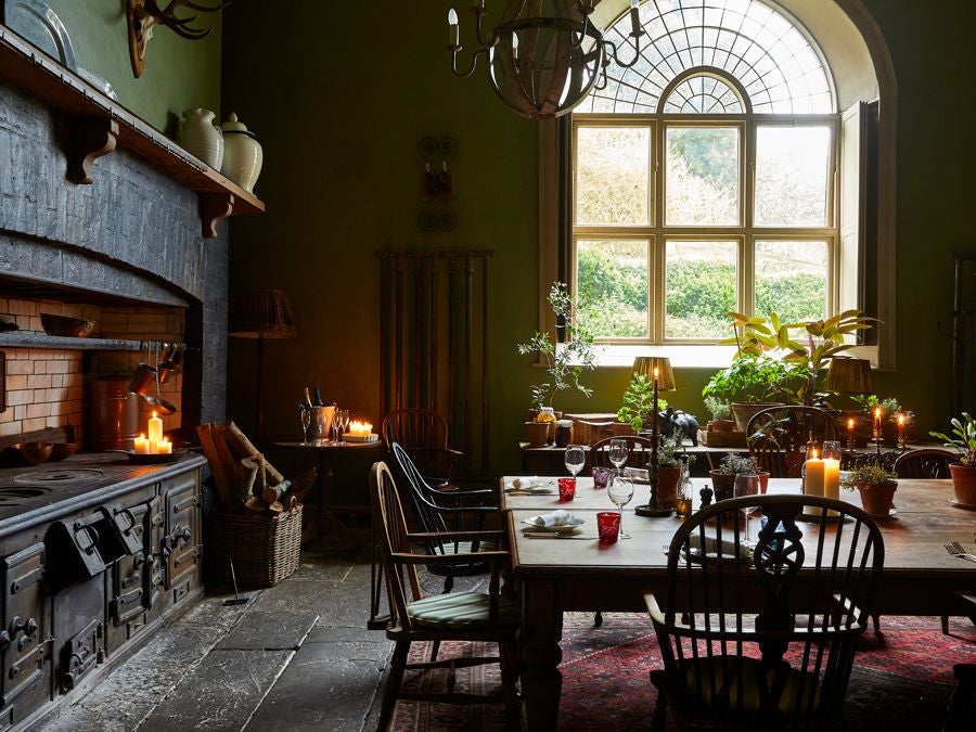 Rustic luxury hotel exterior with stone walls, charming boutique windows, and warm lighting in a historic UK setting at dusk