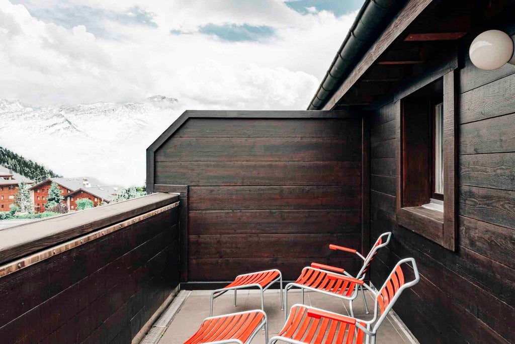 Luxurious Swiss junior suite terrace with modern alpine design, featuring sleek furnishings, panoramic mountain views, and elegant outdoor seating area.