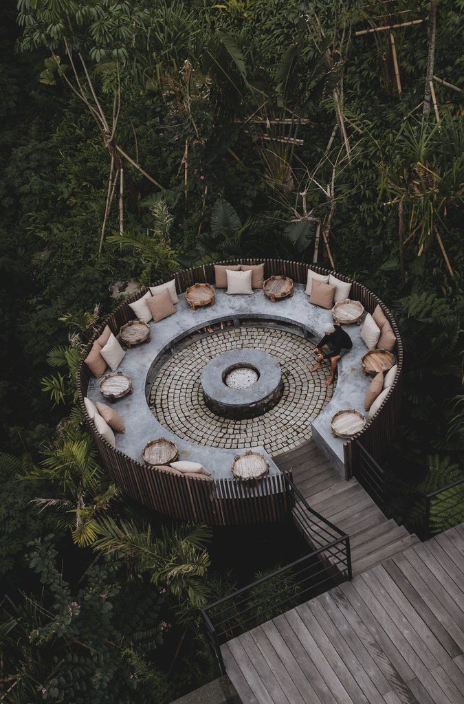 Luxury infinity pool overlooks misty mountains of Bali, surrounded by lush jungle and wooden cabin deck at golden hour