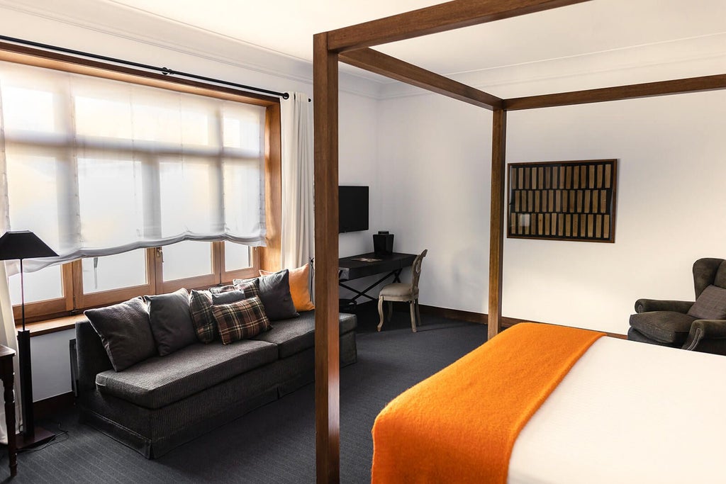 Elegant superior hotel room with modern decor, plush white bedding, minimalist design, warm lighting, and sleek wooden furnishings at Primero Primera Hotel & Club in Spain