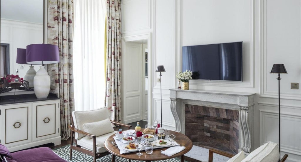 Elegant Paris hotel master bedroom with plush white bedding, chic neutral decor, and expansive city view through large windows at J.K. Place luxury boutique hotel