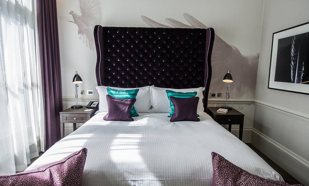 Elegant deluxe hotel room with contemporary design, featuring plush white bedding, sophisticated artwork, and modern minimalist furnishings in a chic United Kingdom setting