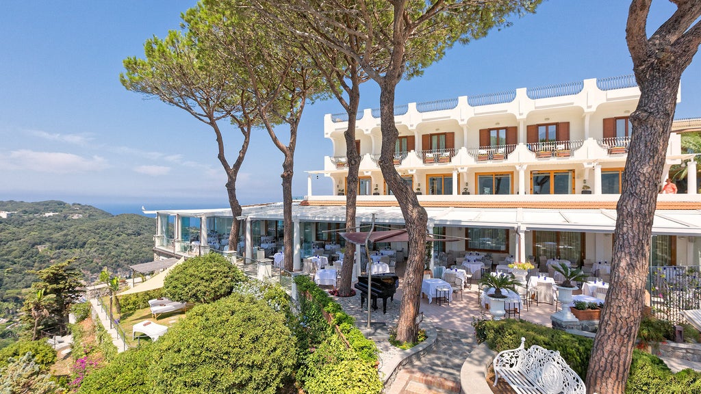 Luxurious infinity pool overlooking the Bay of Naples at sunset, with sun loungers and panoramic views of Mediterranean coastline