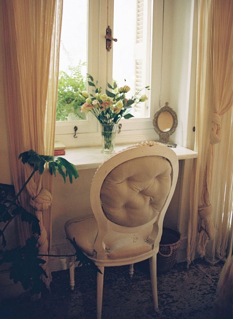 Elegant Athens hotel room with soft dusty rose linens, minimalist marble decor, large window overlooking city skyline, creating romantic and sophisticated atmosphere